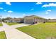 Home featuring a well-kept lawn, gray exterior, and an attached two-car garage at 10420 E 161St St, Summerfield, FL 34491