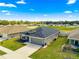 Exterior view of a gray home with a well-maintained lawn and attached garage at 10420 E 161St St, Summerfield, FL 34491