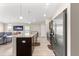 Kitchen island featuring granite countertops and stainless steel appliances with the living room in the background at 10420 E 161St St, Summerfield, FL 34491