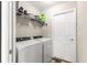 Laundry room with a new white washer and dryer, shelving, and a white door at 10420 E 161St St, Summerfield, FL 34491