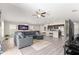 Open concept living room with a gray sofa, a dining table, and a kitchen with stainless steel appliances at 10420 E 161St St, Summerfield, FL 34491