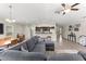 Open-concept living room with modern gray sofa, dining area, and kitchen with stainless steel appliances at 10420 E 161St St, Summerfield, FL 34491