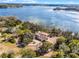 Aerial view of beautiful lakeside home and dock with mature trees at 10944 Autumn Ln, Clermont, FL 34711