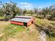 Aerial view of the large red barn, surrounding grassland and fencing at 10944 Autumn Ln, Clermont, FL 34711