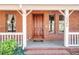 Inviting front entrance with a classic wooden door, brick accents and manicured shrubs at 10944 Autumn Ln, Clermont, FL 34711