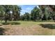 Expansive front yard featuring mature trees with Spanish moss and classic wooden fence at 10944 Autumn Ln, Clermont, FL 34711