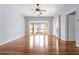 Living room with bay windows, hardwood floors, ceiling fan, and access to the patio at 10944 Autumn Ln, Clermont, FL 34711