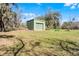 Exterior angle of the green metal shed and surrounding greenery at 10944 Autumn Ln, Clermont, FL 34711