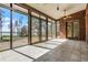 Enclosed sunroom with brick accent wall, tile floors, and a view of the lake at 10944 Autumn Ln, Clermont, FL 34711