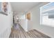 Bright hallway with neutral paint, art and wood-look flooring, leading to other areas of the home at 11090 Silver Surfer Aly, Winter Garden, FL 34787