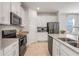 Modern kitchen featuring granite countertops, stainless steel appliances, and white cabinetry at 11090 Silver Surfer Aly, Winter Garden, FL 34787