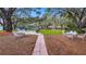 Expansive backyard featuring mature trees, lush lawn, and waterfront access with multiple seating areas at 11136 Bronson Rd, Clermont, FL 34711