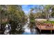 Beautiful waterfront view shows a dock with canopy on a tree-lined canal at 11136 Bronson Rd, Clermont, FL 34711