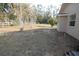 Large backyard featuring a white fence, a few trees and a green hose in the grass at 11740 E Highway 25, Ocklawaha, FL 32179