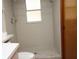 Bathroom featuring a walk-in shower with gray tile and a small window at 11740 E Highway 25, Ocklawaha, FL 32179