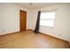 Bedroom with wood floor, a ceiling fan, and a window with curtains at 11740 E Highway 25, Ocklawaha, FL 32179