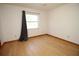 Bedroom with wood floor, a ceiling fan, and a window with curtains at 11740 E Highway 25, Ocklawaha, FL 32179