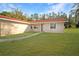 Single story home showcasing a lush lawn and a traditional facade with a clean pathway to the entrance at 11740 E Highway 25, Ocklawaha, FL 32179