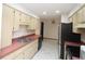 Kitchen featuring light-colored cabinets, a stainless steel refrigerator, and tile flooring at 11740 E Highway 25, Ocklawaha, FL 32179