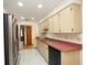 Kitchen featuring light-colored cabinets, a stainless steel refrigerator, and tile flooring at 11740 E Highway 25, Ocklawaha, FL 32179