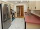 Bright kitchen featuring stainless steel refrigerator and modern white marble-patterned flooring at 11740 E Highway 25, Ocklawaha, FL 32179