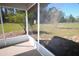 Enclosed screened patio that offers a tranquil setting overlooking a private, treed yard and blue sky at 11740 E Highway 25, Ocklawaha, FL 32179