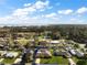 Aerial view of a single story brick home, in a neighborhood, surrounded by trees at 12320 Blue Heron Way, Leesburg, FL 34788