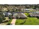 Aerial view of a single story brick home with an attached garage, and lawn at 12320 Blue Heron Way, Leesburg, FL 34788