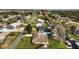 Aerial view of a neighborhood showcasing homes, streets, and a glimpse of the lake at 12320 Blue Heron Way, Leesburg, FL 34788