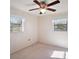 A bedroom with a ceiling fan, neutral walls, and a pair of windows providing natural light at 12320 Blue Heron Way, Leesburg, FL 34788