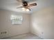 A compact room with neutral walls, a ceiling fan, and a window with blinds at 12320 Blue Heron Way, Leesburg, FL 34788