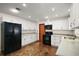 Modern kitchen with sleek black appliances, white cabinets, and unique flooring at 12320 Blue Heron Way, Leesburg, FL 34788