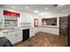 Traditional kitchen with white cabinets, stone floors, and a pass-through to a stone fireplace room at 12320 Blue Heron Way, Leesburg, FL 34788