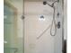 Shower with tiled walls, glass doors, shower head, and a grab bar for accessibility at 12320 Blue Heron Way, Leesburg, FL 34788