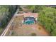 Aerial view of the backyard featuring a screened-in pool and mature trees at 1236 Selman Rd, Leesburg, FL 34748