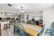 Dining area featuring a wooden table with blue chairs, opening to the kitchen and a flexible office space at 1236 Selman Rd, Leesburg, FL 34748