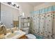 Bright bathroom features a vanity, toilet, towel rack, and a shower with a blue decorative starfish shower curtain at 12497 Se 92Nd Ave, Summerfield, FL 34491