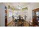 Cozy dining area with wood floors, a round table with four chairs, and windows with decorative valances at 12497 Se 92Nd Ave, Summerfield, FL 34491