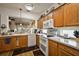 Kitchen featuring wooden cabinets, white appliances, and decorative dishware on top of cabinets at 12497 Se 92Nd Ave, Summerfield, FL 34491