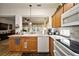 Bright kitchen with wooden cabinets, white appliances, and an open view to the living room at 12497 Se 92Nd Ave, Summerfield, FL 34491