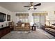 Cozy living room featuring comfortable seating, a ceiling fan, and natural light at 12497 Se 92Nd Ave, Summerfield, FL 34491