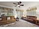 Inviting living room with plush sofas, ceiling fan, and large windows at 12497 Se 92Nd Ave, Summerfield, FL 34491