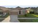 Charming one-story home featuring a 2 car garage and well-maintained front lawn at 125 Sunny Day Way, Davenport, FL 33897