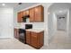 Well-designed kitchen featuring warm wood cabinets, white countertops, and sleek black appliances at 125 Sunny Day Way, Davenport, FL 33897