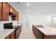 Spacious kitchen showcasing dark wood cabinets, white countertops and a black oven range at 125 Sunny Day Way, Davenport, FL 33897