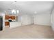 Open-concept living room and kitchen with neutral colors, carpeted floors, and wood cabinetry at 125 Sunny Day Way, Davenport, FL 33897