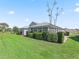 A beautiful screened-in patio extends to the backyard with beautiful landscaping and green lawn at 1256 Camero Dr, The Villages, FL 32159