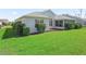 A well-manicured lawn and landscaping surrounds this home and enclosed back patio at 1256 Camero Dr, The Villages, FL 32159