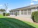 A beautiful screened-in patio extends to the backyard with beautiful landscaping, a green lawn, and solar panels at 1256 Camero Dr, The Villages, FL 32159