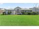 A well-manicured lawn and landscaping surrounds this home and enclosed back patio at 1256 Camero Dr, The Villages, FL 32159